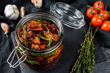 Zeytinyağında kurutulmuş domates, baharat ve bitki tarifi. Siyah arka plan. Üst görünüm