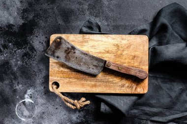 Eski çizik ahşap kesme tahtasındaki et satırı. Karanlık arka plan. Üst Manzara. Boşluğu kopyala