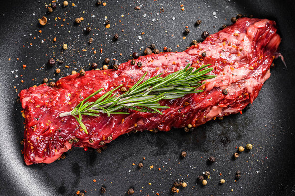 Raw skirt, machete steak in a pan with cooking ingredients. Gray background. Top view.