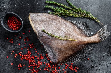 Çiğ taze John Dory balığı, pembe biber ve kekik. Siyah arka plan. Üst görünüm.