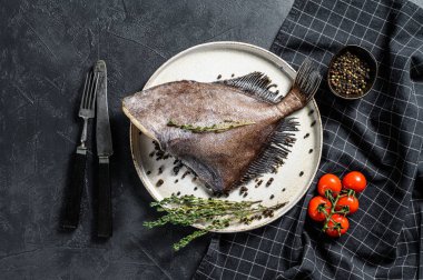 Pembe biber ve kekik ile John Dory balığı. Siyah arka plan. Üst görünüm.
