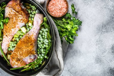 Tavuk yahnisi. Maydanozlu, bezelyeli, kerevizli ve patatesli but tarifi. Gri arka plan. Üst Manzara. Metin için boşluk.