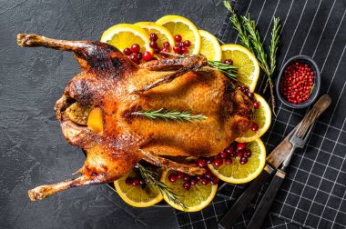Portakal ve Rosmarina ile doldurulmuş fırında kaz. Kutlama masası. Siyah arka plan. Üst görünüm