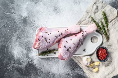 Beyaz kesim tahtasında baharatlı hindi budu. Gri arka plan. Üst Manzara. Metin için boşluk.