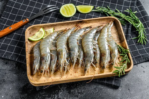 Taze çiğ langoustine karidesler, tahta tepside karidesler. Siyah arka plan. Üst görünüm.