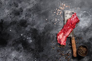 Çiğ etek, satırda pala bifteği. Siyah arka plan. Üst Manzara. Boşluğu kopyala.