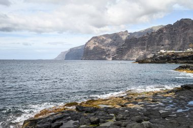 Volkanik kıyılarda siyah kayalar var. Seçici odaklanma. Los Gigantes, Tenerife.