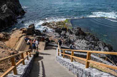 Volkanik bir sahilde okyanus suyu olan terk edilmiş bir açık havuz. Seçici odaklanma. 20.01.2020 Los Gigantes, Tenerife.