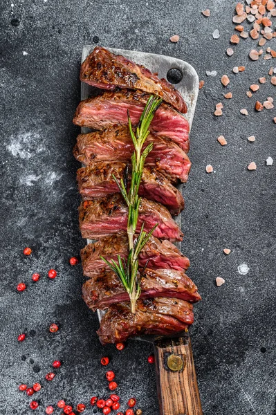 Grilled top blade, Denver steak. Marble meat beef. Black background. Top view.