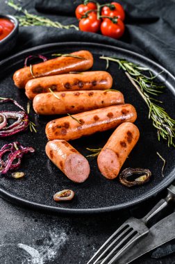 Soğanlı, sarımsaklı ve biberiyeli kızarmış tavuk sosisi. Siyah arka plan. Üst görünüm.