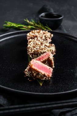 Susamlı ızgara ton balığı bifteği. Siyah arka plan. Üst görünüm.