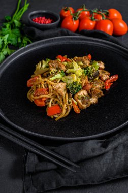 Tavuk kızartması ve sebze, soya sosu, wok. Geleneksel Asya yemekleri. taş siyah masa.