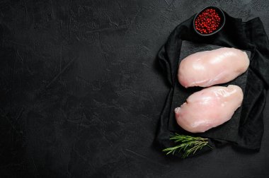 Kesme tahtasında çiğ tavuk filetosu. Taze göğüsler. Siyah arka plan. Çiftlik organik eti