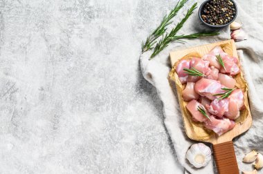 Baharatlı küp kesilmiş çiğ tavuk filetosu. Gri arka plan. Üst Manzara. Metin için boşluk.