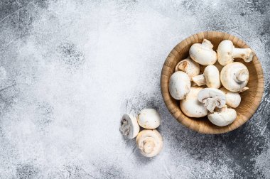 Bambu kasesinde çiğ beyaz mantar. Gri arka plan. Üst Manzara. Metin için boşluk.