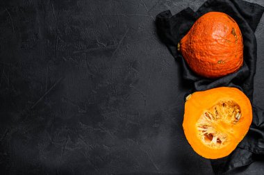 Siyah arka planda çiğ turuncu balkabağı. Mesaj için yer var. Vejetaryen mutfağı.