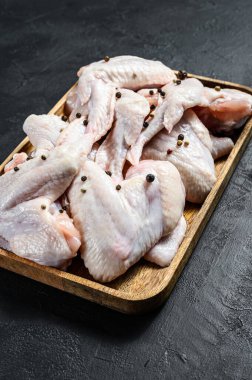 Çiğ tavuk kanadı. Çiftlik organik kümes hayvanları. Üst Manzara. Siyah arkaplan