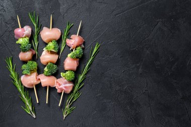 Şiş üzerinde taze çiğ tavuk parçaları. Siyah arka plan. Üst Manzara. Metin için boşluk.