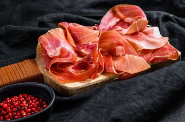 Prosciutto Crudo, İtalyan salamı, parma jambonu. Antipasto tabağı. Siyah arkaplan, üst görünüm