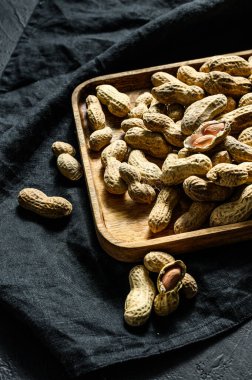 Kabuklu fıstıklar. Organik çiğ yer fıstığı. Siyah arka plan. Üst görünüm.