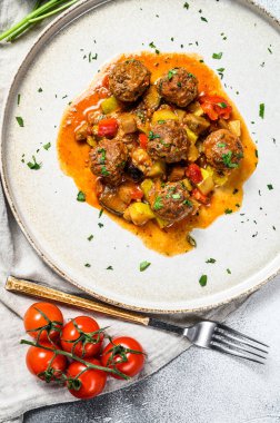 Domates soslu köfte ve tavada sebze. Gri arka plan. Üst görünüm.