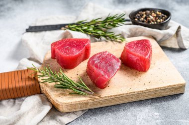 Doğrama tahtasında taze ton balığı bifteği. Gri arka plan. Üst görünüm.