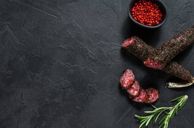 Fuet, Salam ve biberiye filizi. Geleneksel İspanyol sosisi. Siyah arka plan. Üst Manzara. Metin için boşluk.