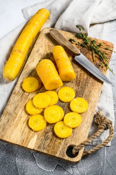 Sliced fresh Yellow carrots without tops, the concept of cooking vegetables. Gray background. Top view.