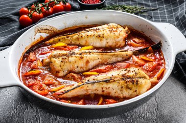 Fırın kabında domatesli maymunbalığı pişirmek. Taze deniz ürünleri. Gri arka plan. Üst görünüm.