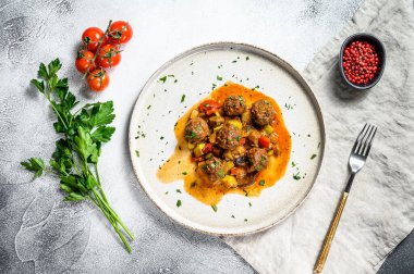 Domates soslu köfte ve tavada sebze. Gri arka plan. Üst görünüm.