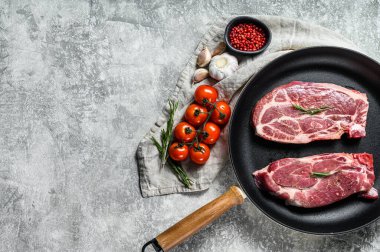 Kızartma tavasında taze domuz eti. Mermer çiftlik eti. Gri arka plan. Üst Manzara. Metin için boşluk.