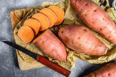 Doğrama tahtasında çiğ patates, organik yer elması. Çiftlik sebzeleri. Gri arkaplan.