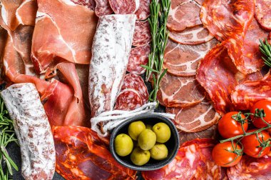 Geleneksel İspanyol mezelerinden yapılmış bir tabak et. Chorizo, Jamon Serrano, Lomo ve Fuet. Siyah arka plan. Üst görünüm.