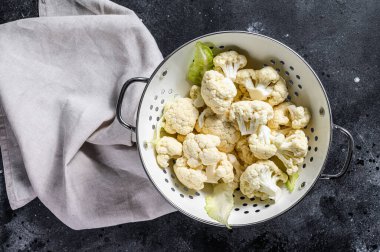 Taze beyaz kafalar karnabaharı süzgeçle temizledi. Siyah arka plan. Üst görünüm.