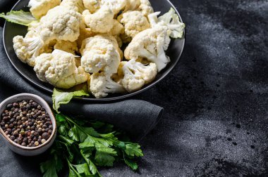 Taze beyaz kafalar karnabaharı bir kasede temizledi. Siyah arka plan. Üst Manzara. Boşluğu kopyala.