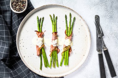 Domuz pastırmasına sarılmış ızgara organik kuşkonmaz. Gri arka plan. Üst görünüm.