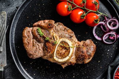 Osso buco, dana inciği. Ossobuco eti. Siyah arka plan. Üst görünüm.