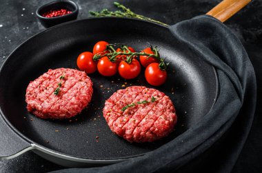 Çiğ kıymalı et pirzolası, tavada köfte. Siyah arka plan. Üst görünüm.