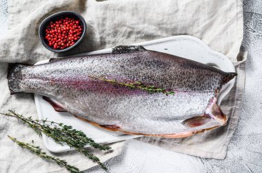 Tuzlu ve kekikli çiğ alabalık. Gri arka plan. Üst görünüm.