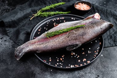 Taze alabalık, tuzlu ve biberiyeli. Siyah arka plan. Üst görünüm.