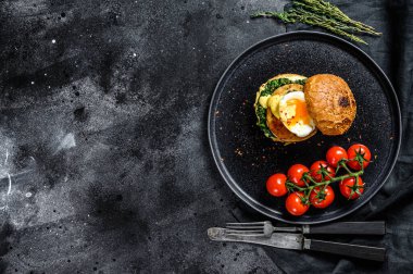 Ev yapımı balık köftesi, balık fileto, yumurta ve ıspanaklı çörek. Siyah arka plan. Üst Manzara. Boşluğu kopyala.