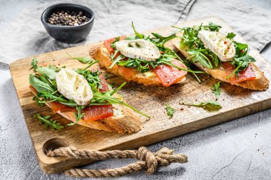 Keçi peynirli bruschetta, roka ve armut reçeli. Gri arka plan. Üst görünüm.