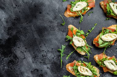 Peynirli sandviç, roka ve armut reçeli. Siyah arka plan. Üst görünüm.