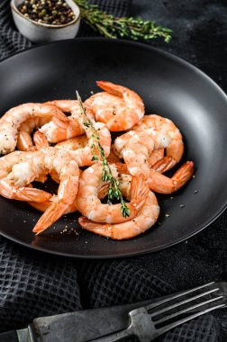 Soyulmuş kral karidesleri, tabakta karidesler. Siyah arka plan. Üst görünüm.