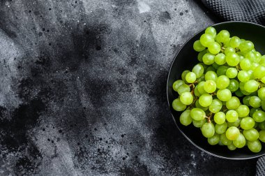 Bir tabakta taze üzümler, sonbaharın meyveleri. Siyah arka plan. Üst Manzara. Boşluğu kopyala.
