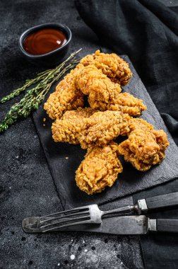 Kızarmış tavuk, patates kızartması ve domates. Siyah arka plan. Üst görünüm.