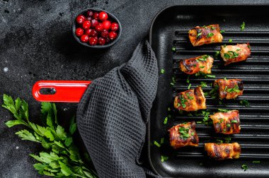 Tavaya sarılmış pastırmalı tavuk göğsü. Siyah arka plan. Üst görünüm.