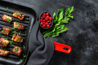 Domuz pastırmasına sarılmış kızarmış tavuk göğsü. Siyah arka plan. Üst Manzara. Boşluğu kopyala.