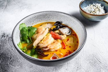 Tom yam kong ya da Tom yum, baharatlı berrak çorba. Tom Yam. Gri arka plan. Üst görünüm.