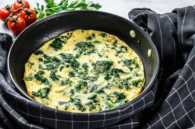 Tavada ıspanaklı peynirli frittata. Gri arka plan. Üst görünüm.